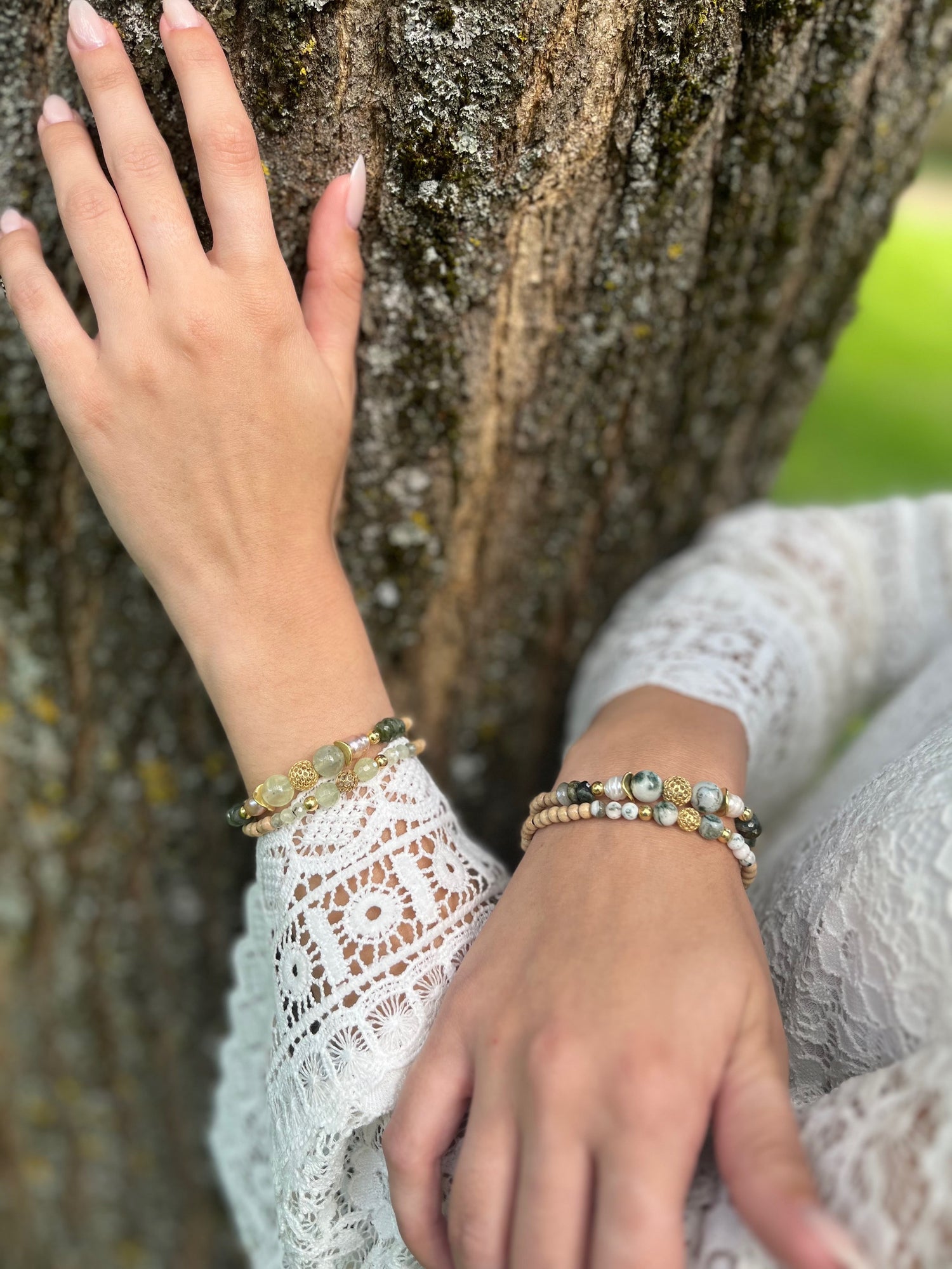 Egérie posant ses mains avec ses bracelets verts sur un arbre