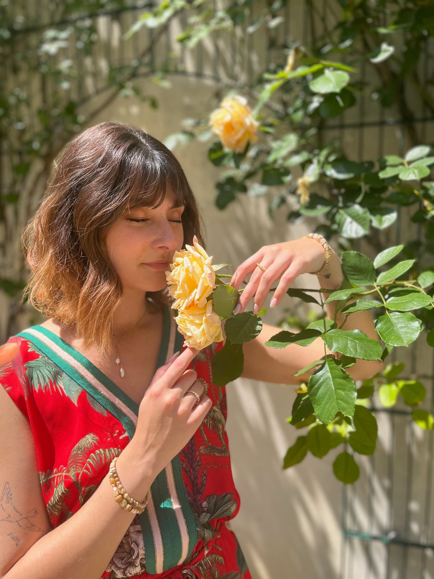 Egérie auprès d'une rose orange et portant les bracelets oranges